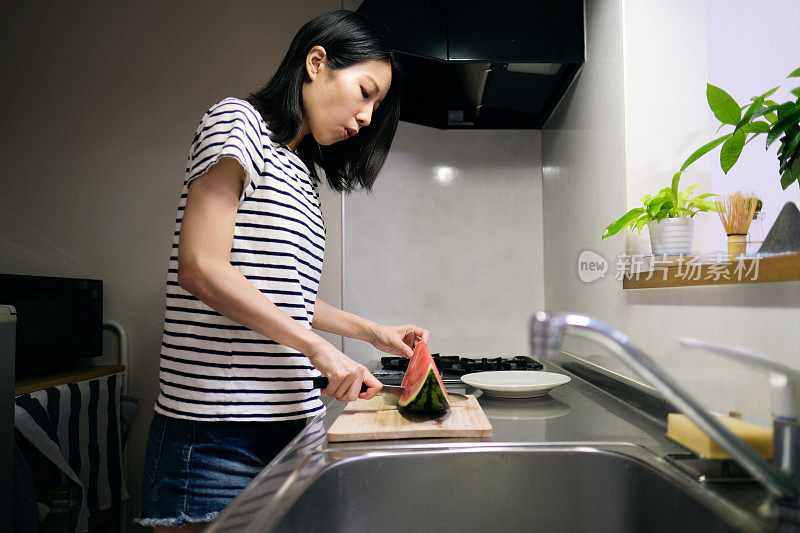 在厨房切西瓜的女人