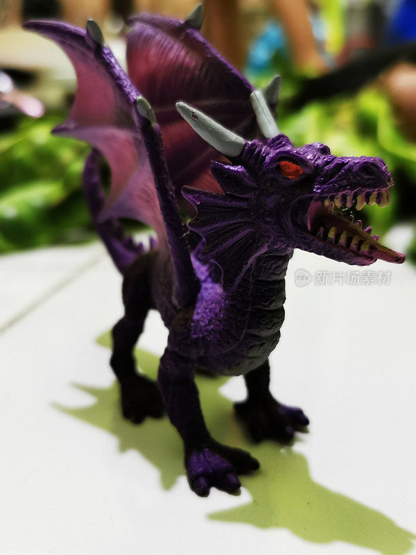 龙形玩具是紫色的，有两个白色的角