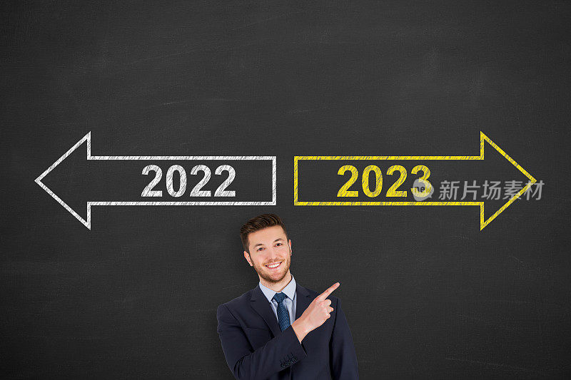 商人在黑板背景上画旧年或2023年