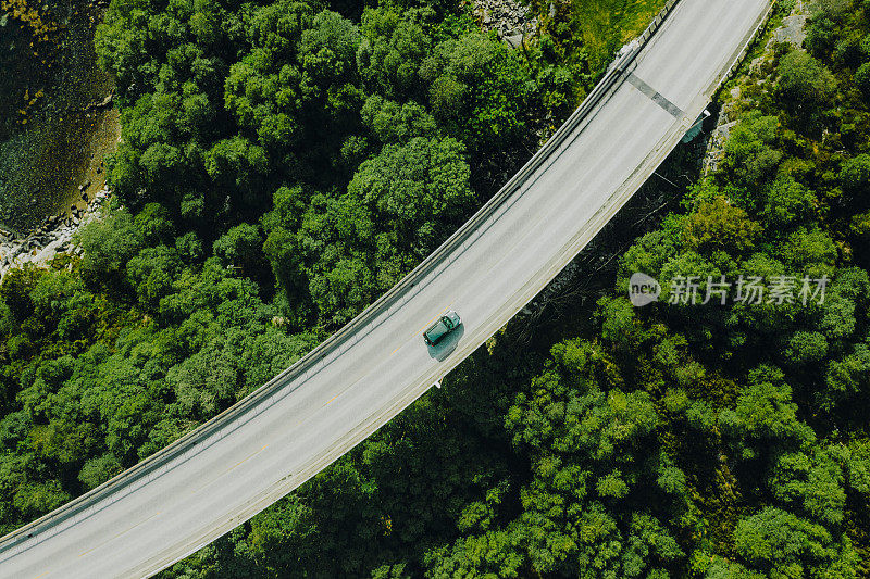 航拍的汽车行驶在挪威绿色森林的道路上
