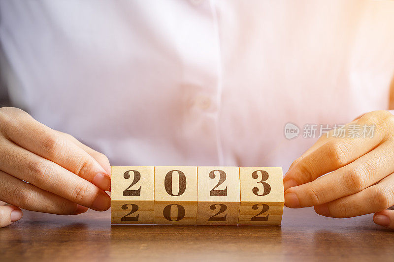 手握的木块上写着2022年的数字，变成了2023年。辞旧迎新的概念，开始新的计划，总结过去一年的计划。
