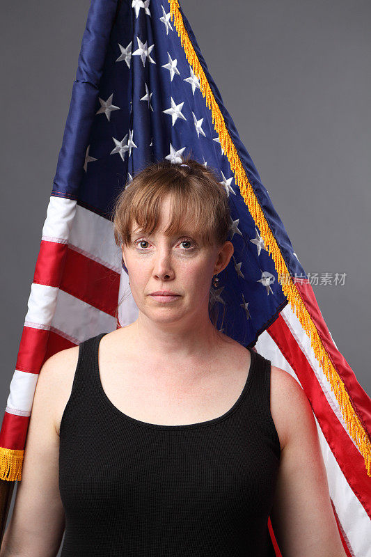 可怜的军人妻子站在美国国旗前