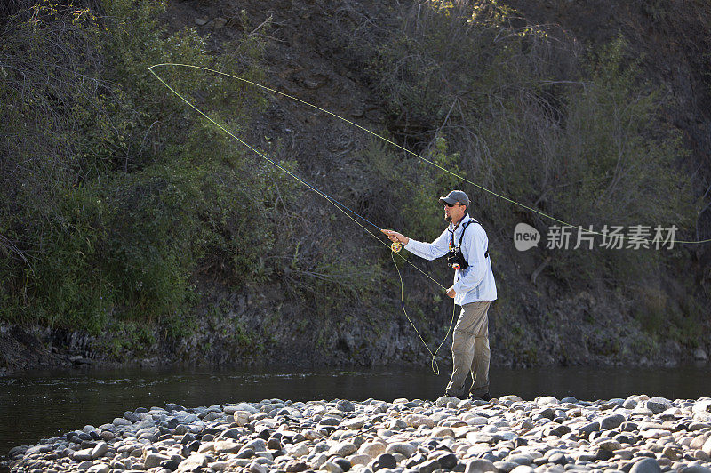 在美国西部的一条河上飞钓鳟鱼。