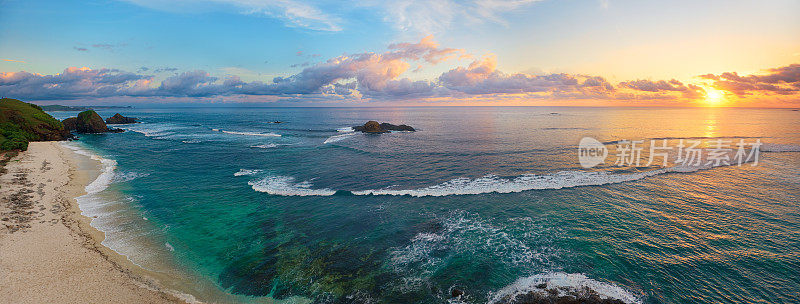 日落时分，热带海滩与冲浪者的全景。