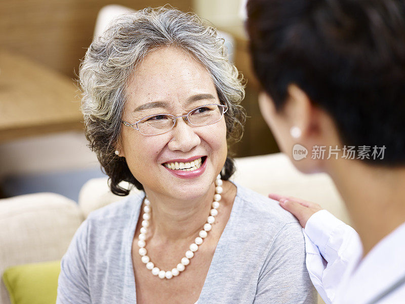 一位年长的亚洲女性在和医生谈话