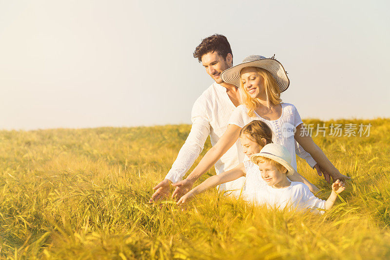 幸福家庭在黄金大麦中享受夏天