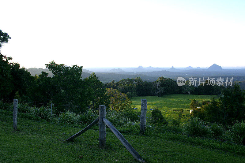 玻璃房子山与雾和前景农场在黎明