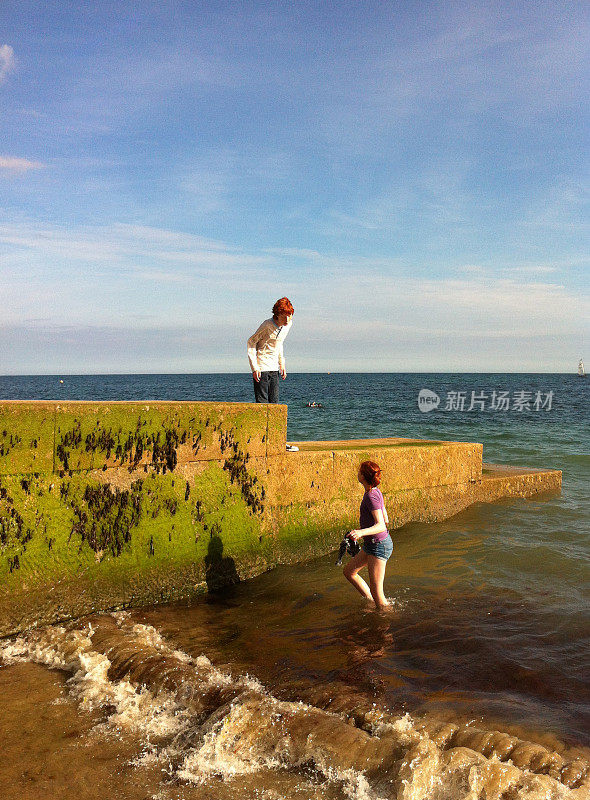 男孩和女孩在海滩上玩海草