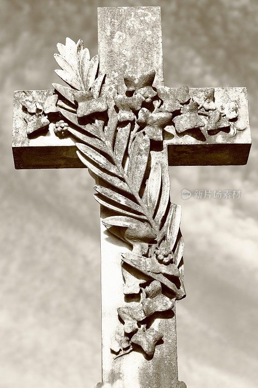 深褐色的石十字架坟墓在一个公共墓地