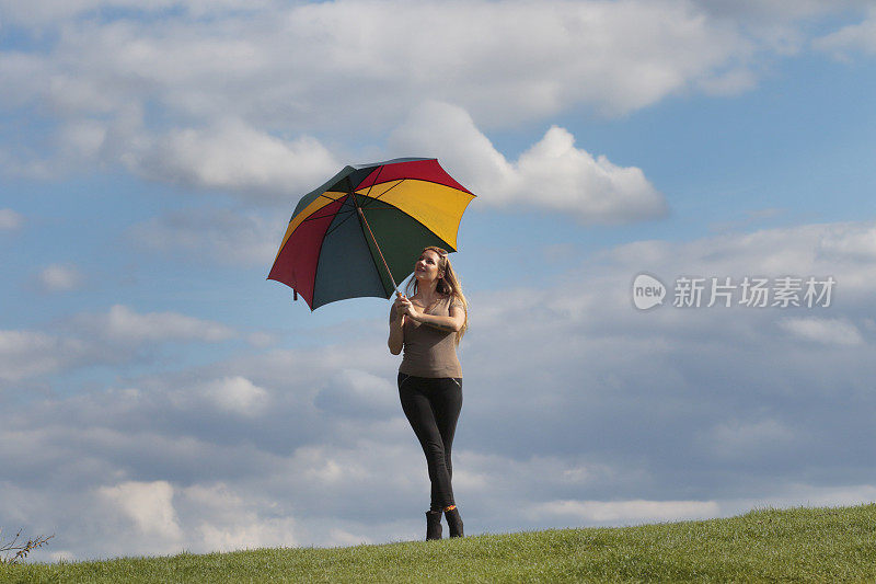 快乐的带着彩虹伞的身材优美的波兰户外女孩