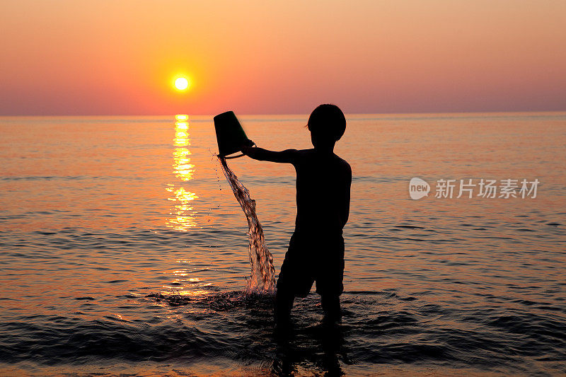 小男孩在伊利湖倾倒水的剪影