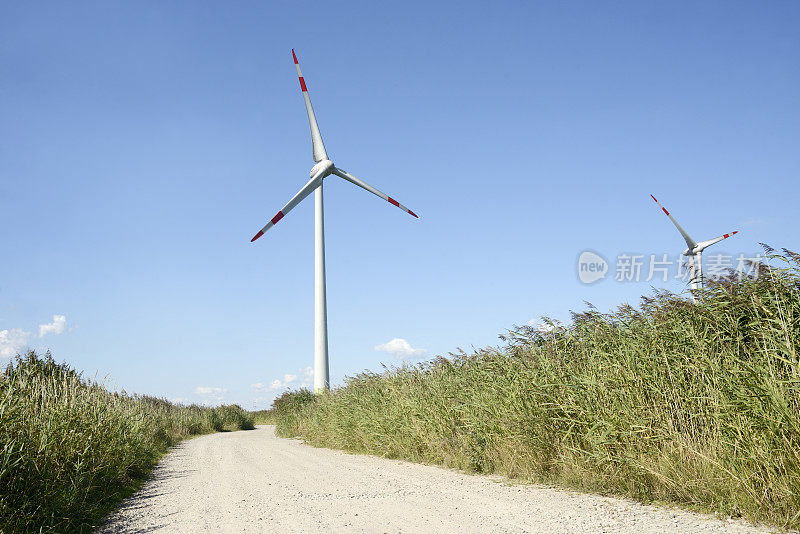 蓝天下乡间小路上的风力涡轮机场