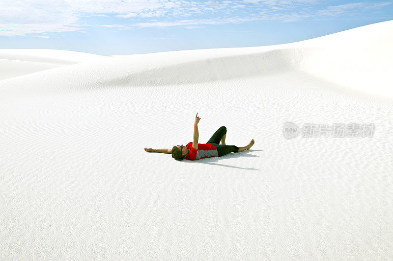 年轻女子躺在白沙上，新墨西哥州，美国