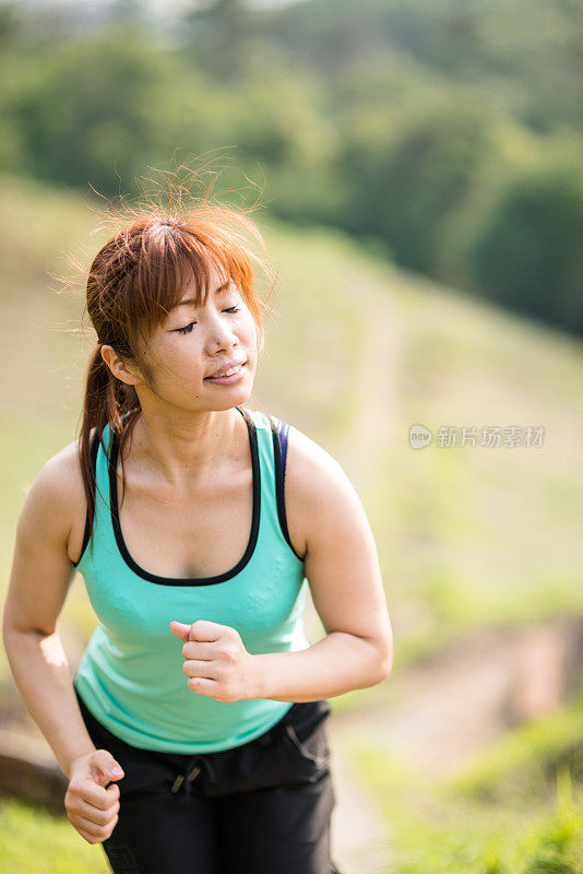 健身日本女人在公园里跑步