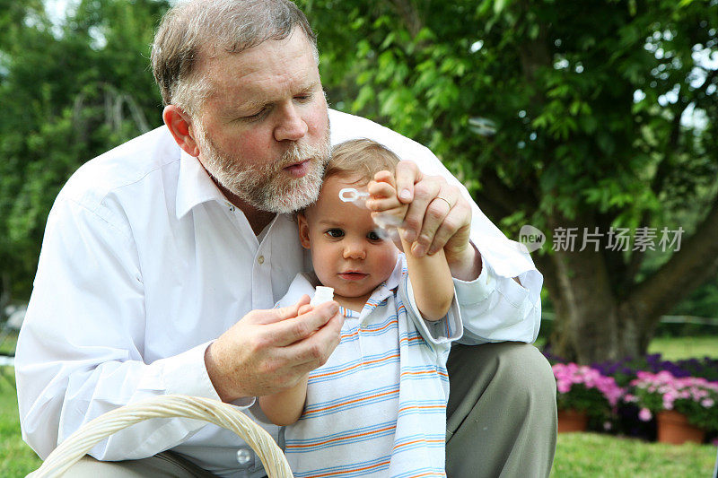 成熟的男人和孙子吹泡泡