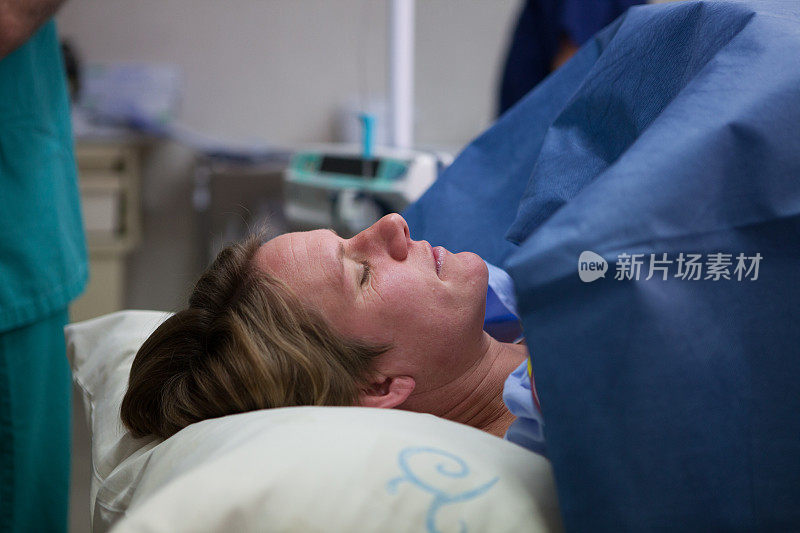 在剖腹产前，疲惫的母亲躺在那里期待着