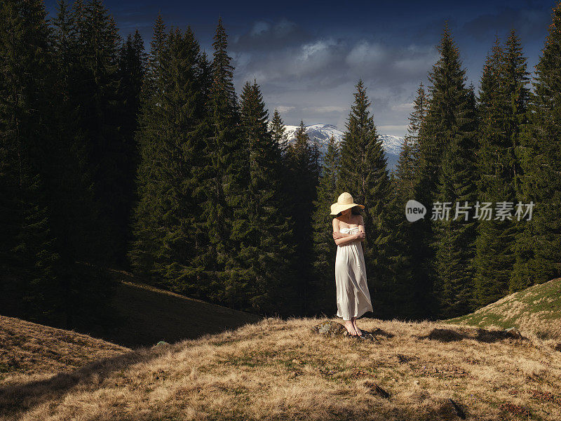年轻女子站在山的山坡上