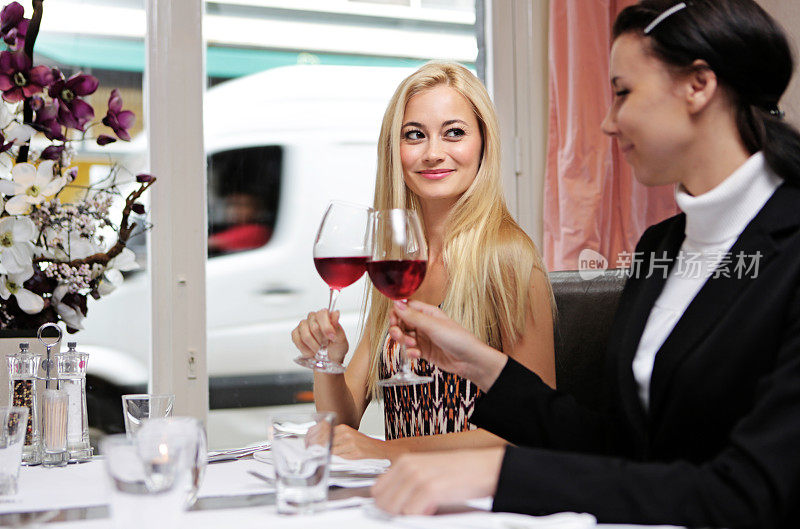 两个女性朋友在餐馆里祝酒
