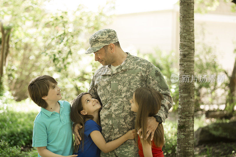 美国退伍军人受到家人的欢迎。三个孩子。首页