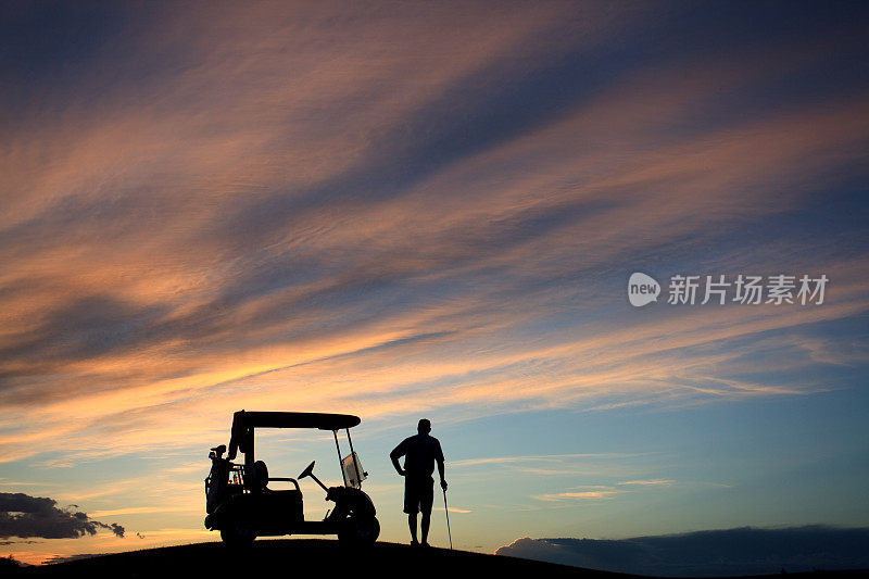 无法辨认的男性高尔夫球站在他的高尔夫球车与天空