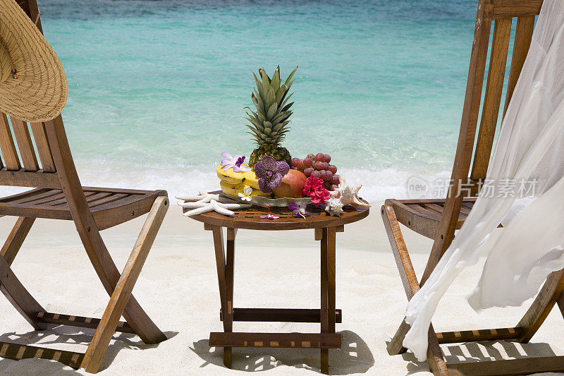 加勒比海滩上摆满异国水果和鲜花的餐桌
