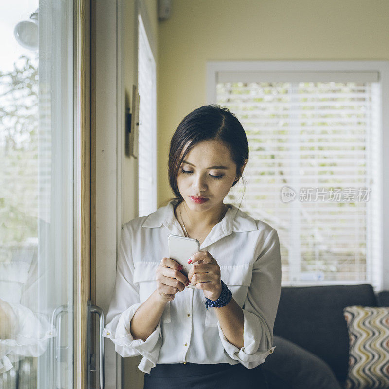 站着看电话留言的亚洲女人