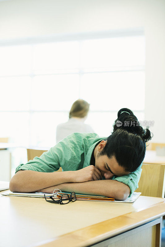 疲惫的学生睡在图书馆里
