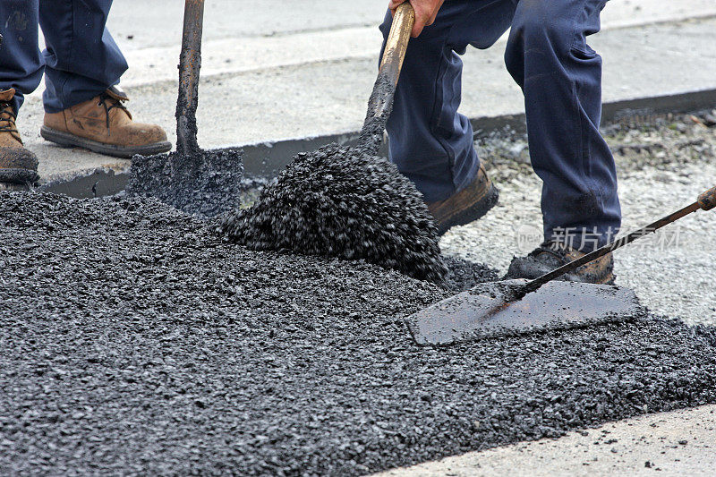 在公路维修现场铲和耙热沥青