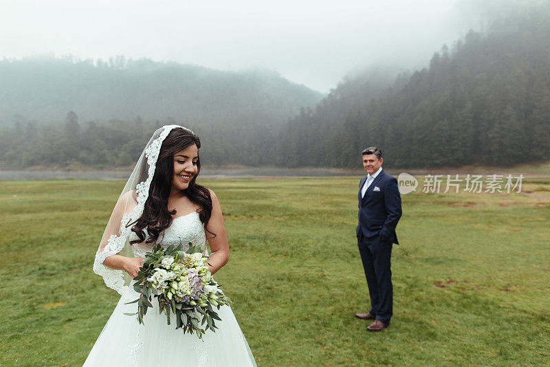 幸福的新娘和新郎站在远处