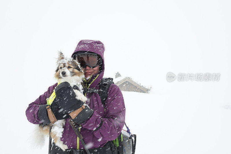 女滑雪者和她的狗在暴风雪