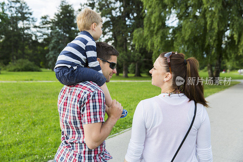 年轻的家庭和他们的小儿子在公园散步....玩得开心