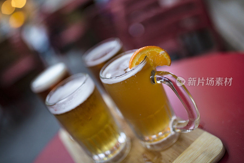 在酒吧庭院的红桌上有四种清爽的啤酒可供选择:杏子啤酒，印度淡啤酒，奶油麦芽啤酒和贮藏啤酒。