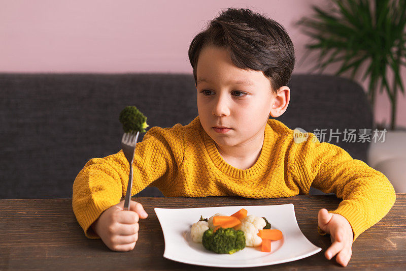 孩子对不得不吃蔬菜很不高兴。