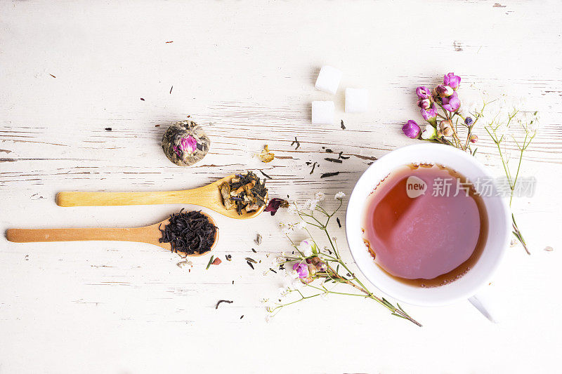 一个被鲜花和茶叶包围的茶杯