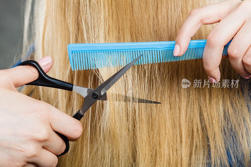 女人剪下光滑的头发。