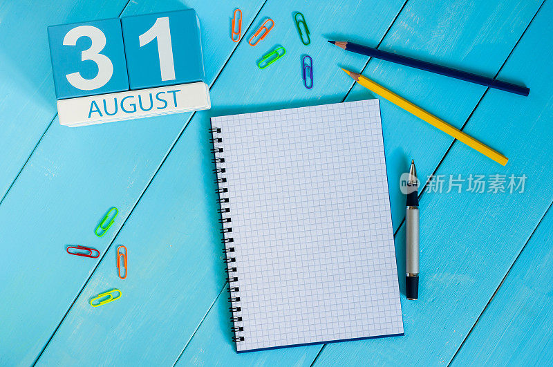 8月31日。图片8月31日的木制彩色日历上的蓝色背景。去年夏天的一天。文本的空白。博客的一天