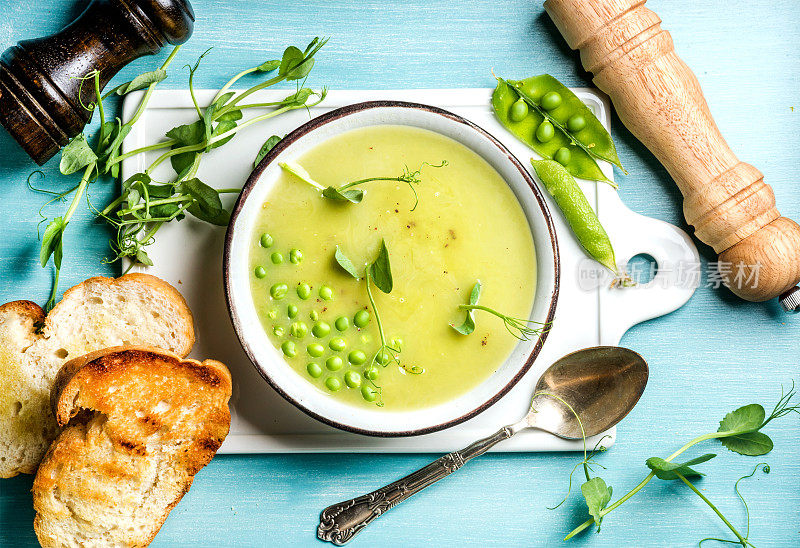 淡雅的夏季绿色豌豆奶油汤与豆芽，面包和香料