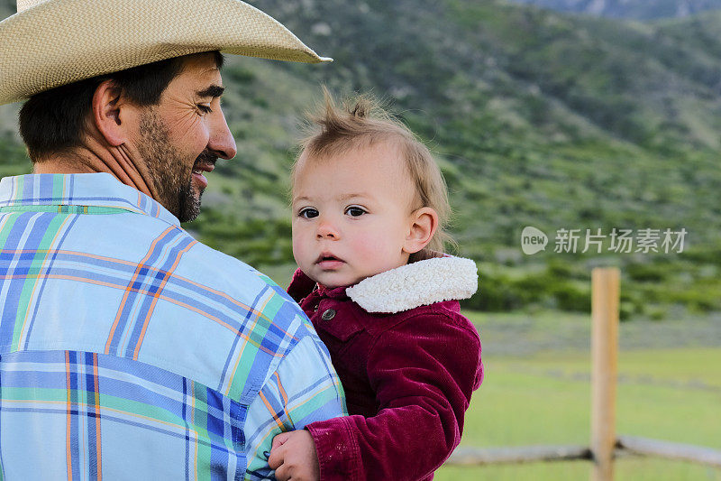 牛仔在田野里抱着一个婴儿