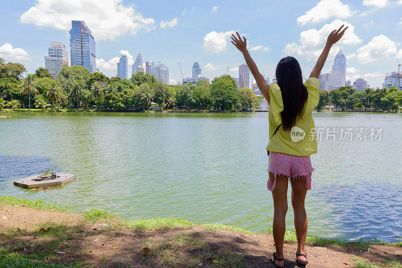 年轻美丽的多民族旅游女人的肖像放松在曼谷的公园泰国