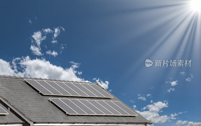 阳光明媚的天空下屋顶上的太阳能电池板