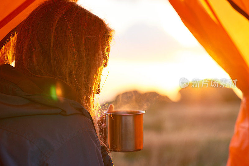 在帐篷里喝茶的女人