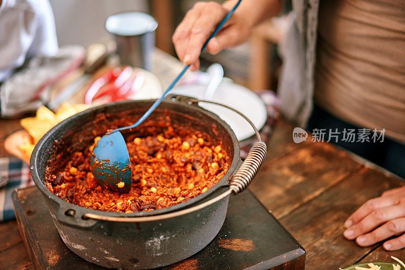 年轻的家庭在家庭厨房里吃辣肉酱