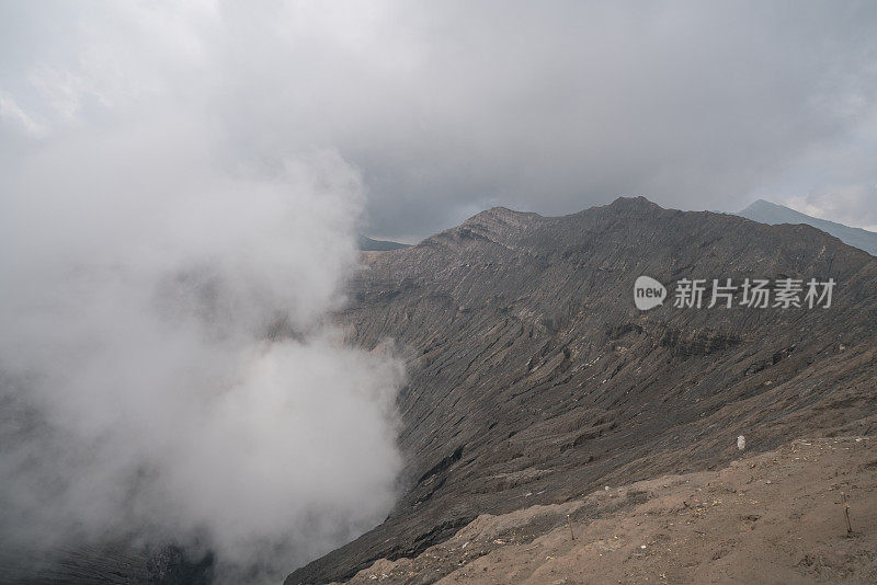 在印度尼西亚东爪哇岛的布罗莫山国家公园，布罗莫火山口边缘有蒸汽。旅游目的地冒险的自然概念