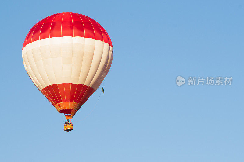 红色气球映衬着蓝色的天空。航空器。篮子里的人。乐趣。夏天娱乐。浪漫的冒险。