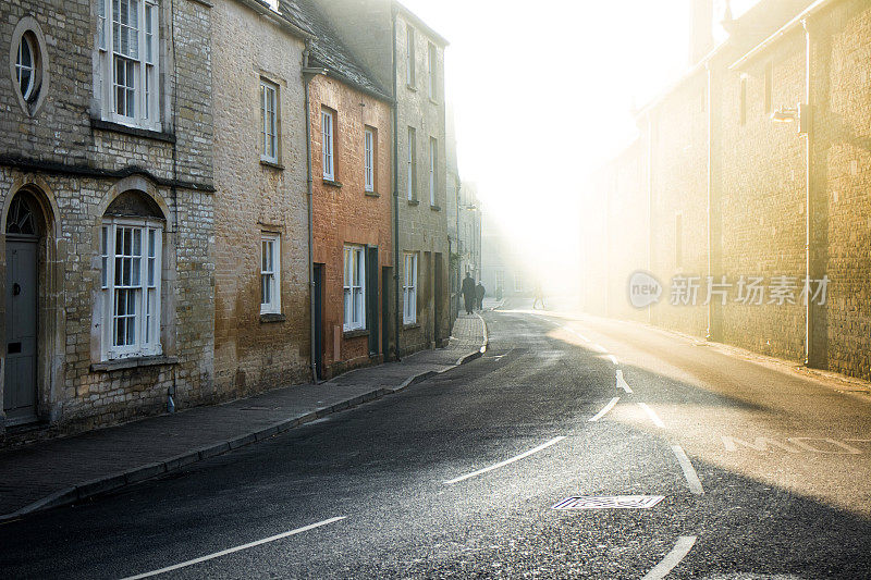赛伦塞斯特科茨沃尔德镇，人们踏着阳光穿过清晨的薄雾去上班