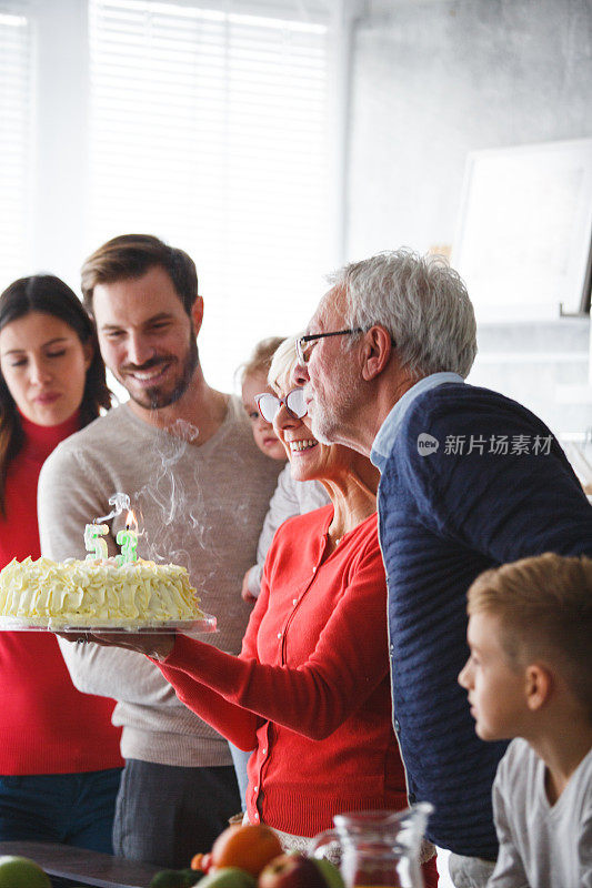 成熟的女人在爱她的家人的陪伴下庆祝生日