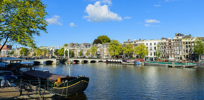 阿姆斯特尔河的全景和瘦桥与运河房屋在阿姆斯特丹，荷兰