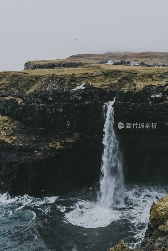 在法罗群岛的风景Múlafossur瀑布坠入大海