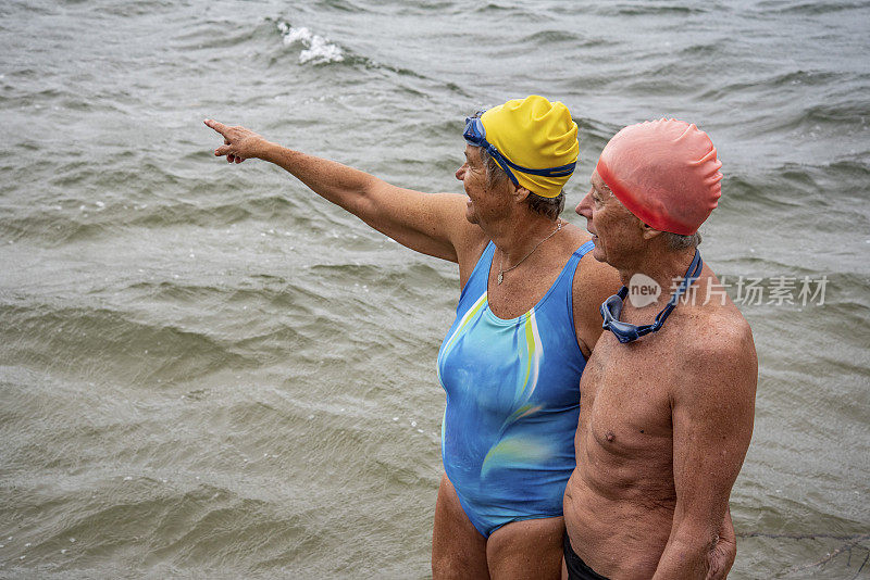 活跃的70多岁的老夫妇正在为他们的海洋游泳做准备。