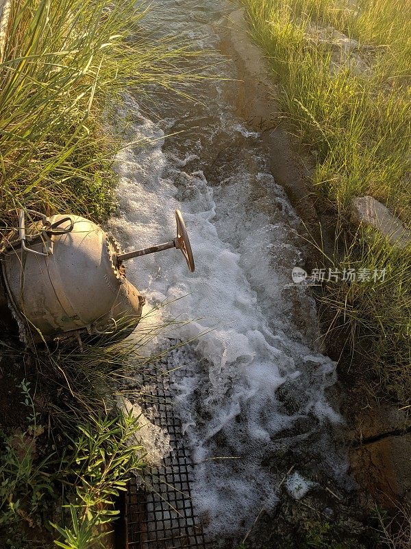 特写水从管落入灌溉渠进入牧场在日落在维珍河谷附近的洛克维尔犹他州